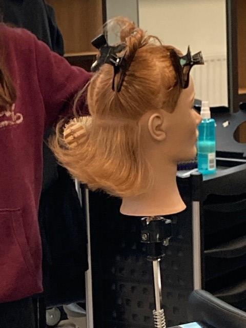 Bilde av elev som klipper dukkehode - Klikk for stort bilde