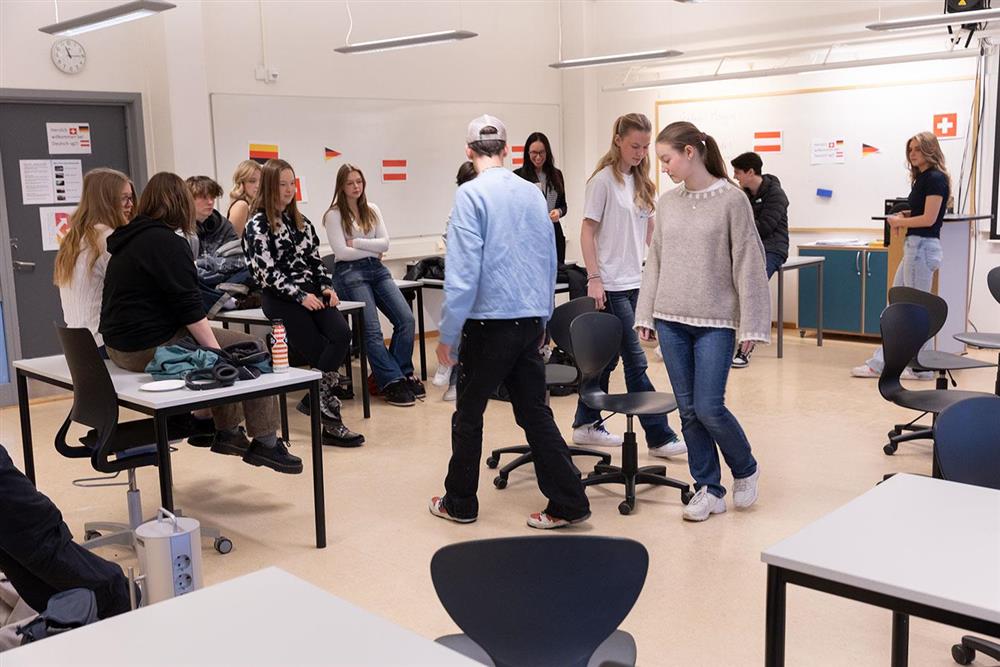 elever som går rundt en stol i klasserommet - Klikk for stort bilde