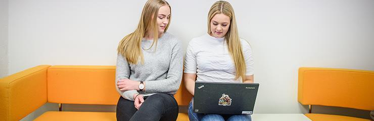 Bildet viser to jenter med bærbar pc på skolens IKT-avdeling - Klikk for stort bilde